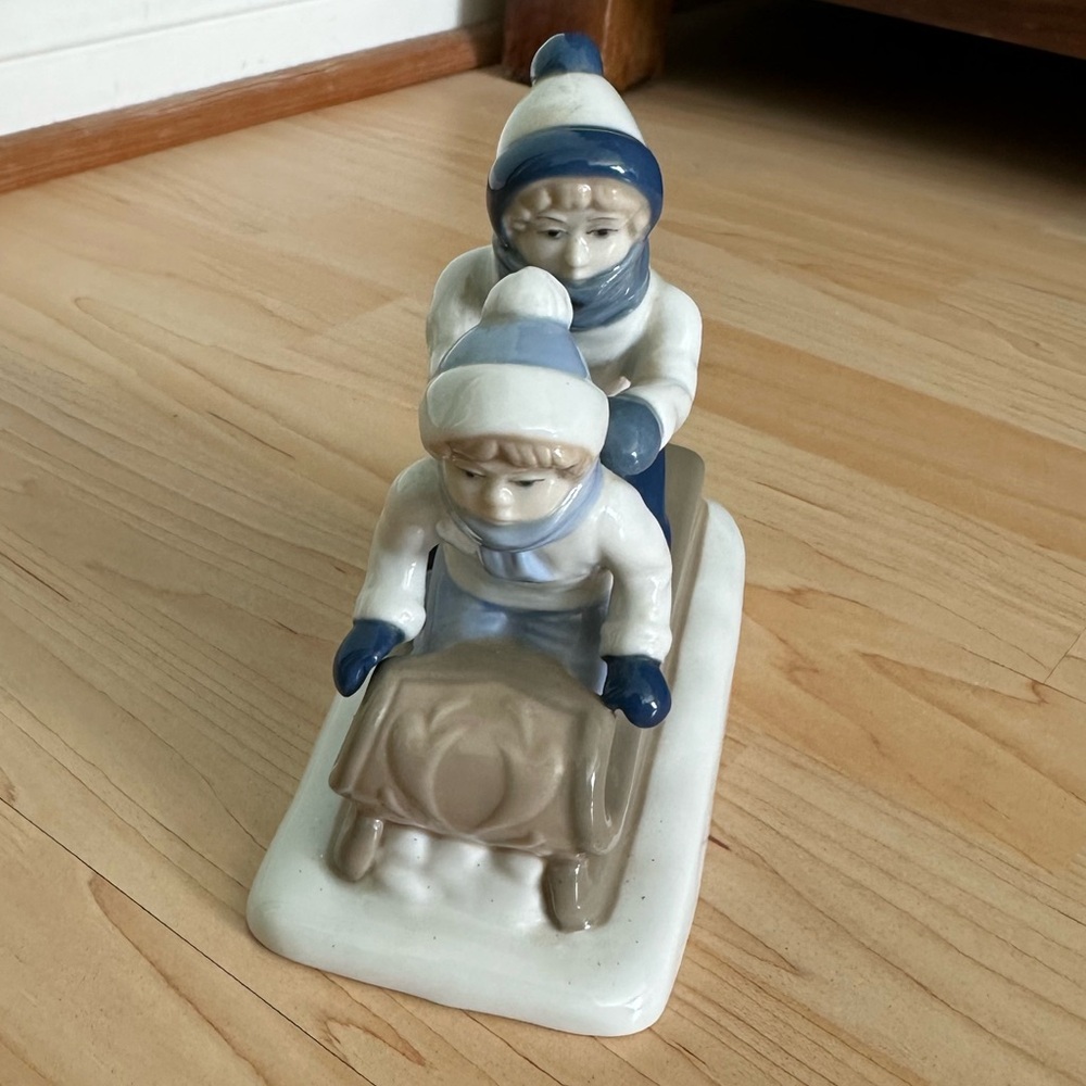 Antique sledding kids figurine